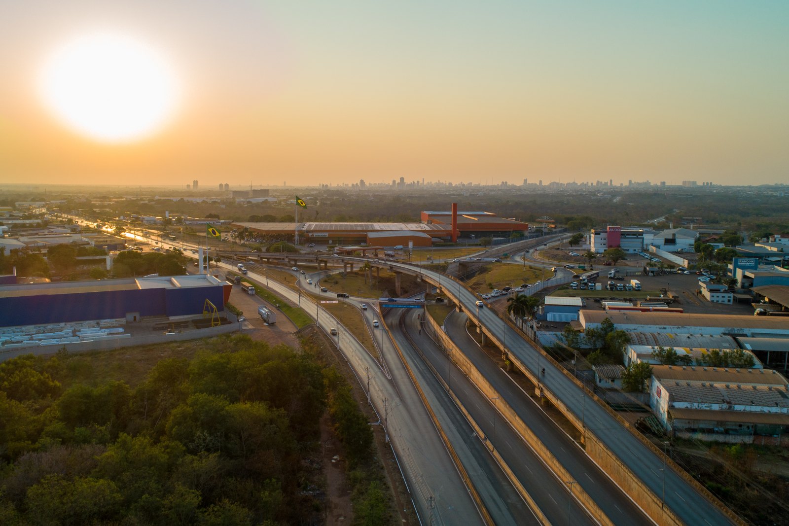 Viaduto em concreto pré-moldado ao entardecer, com a cidade de Cuiabá ao fundo